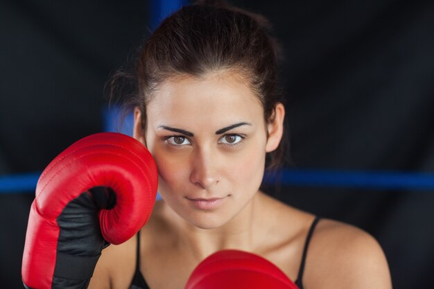 Retrato de primer plano de una bella mujer en guantes de boxeo rojos