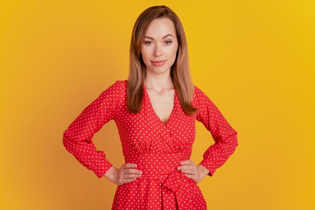 Retrato de primer plano de una cámara de mirada sonriente mujer posando sobre fondo amarillo