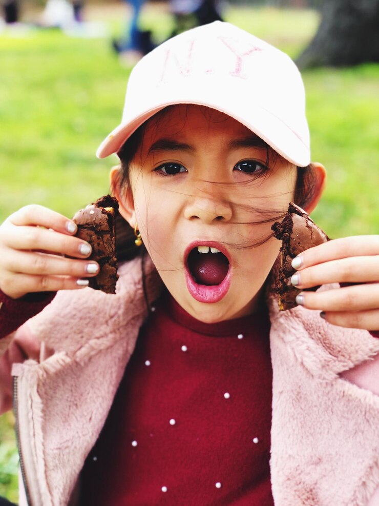 Foto retrato en primer plano de una chica con choque sosteniendo galletas