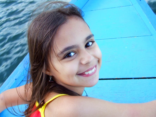 Retrato en primer plano de una chica feliz en un barco en un lago