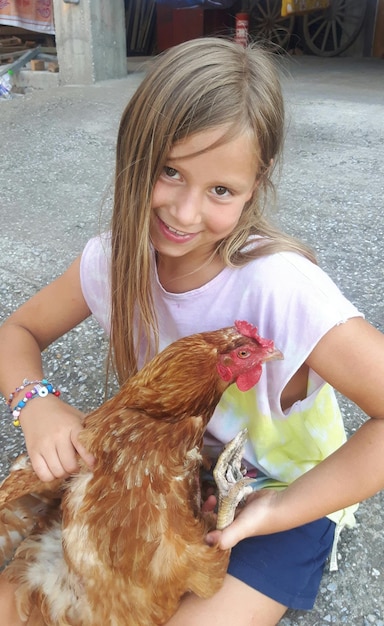 Foto retrato en primer plano de una chica feliz con una gallina