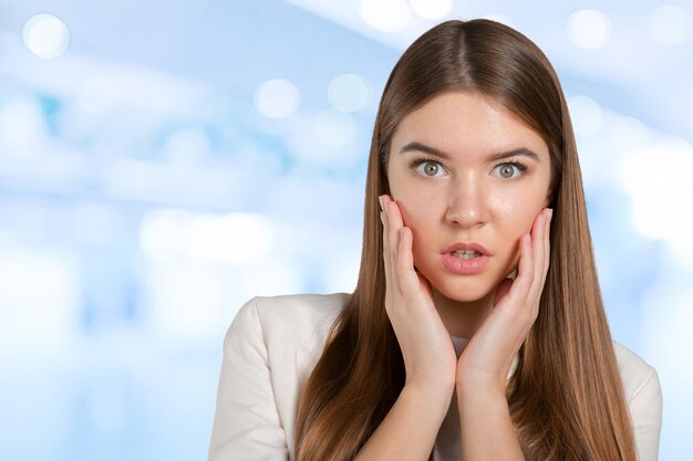 Retrato de primer plano de una chica hermosa sorprendida sosteniendo su cabeza