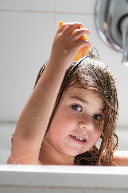 Retrato en primer plano de una chica con jabón en el baño