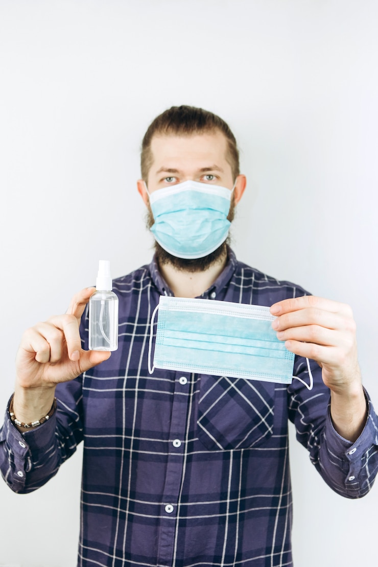 Foto un retrato de primer plano de un chico emocional en una máscara médica con un desinfectante en sus manos. detener la propagación de la infección por coronavirus. covid 2019