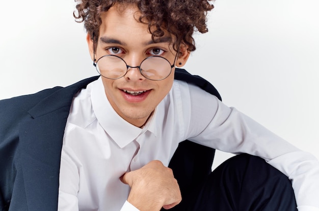 Foto retrato en primer plano de un chico guapo con cabello rizado con gafas y en un traje clásico foto de alta calidad