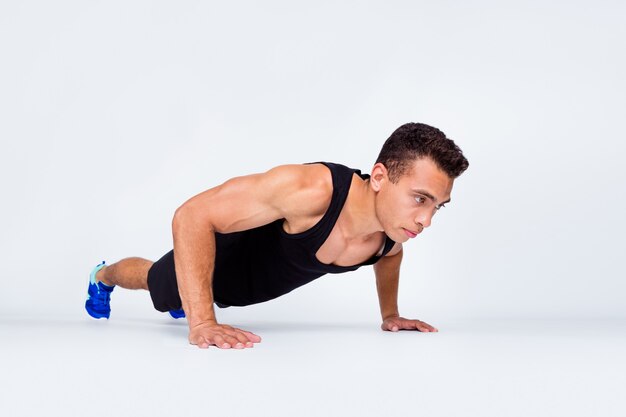 Retrato de primer plano de chico macho fuerte deportivo haciendo flexiones de entrenamiento de motivación