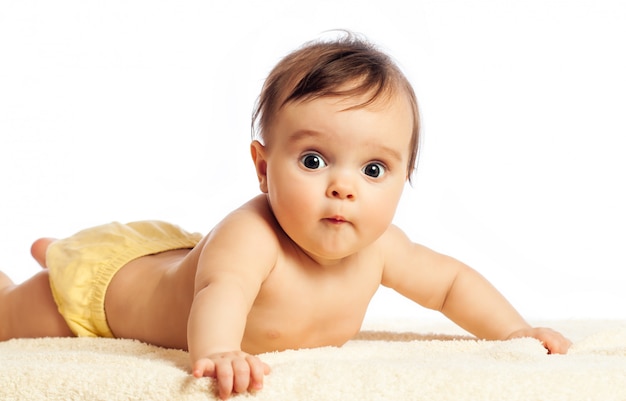 Retrato de primer plano de una divertida niña curiosa de ojos grandes acostada boca abajo