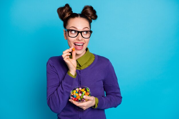 Retrato de primer plano de ella ella agradable atractivo bastante hambriento alegre alegre alegre niña disfrutando de comer caramelo caramelo aislado sobre fondo de color turquesa verde azulado verde brillante brillo vivo