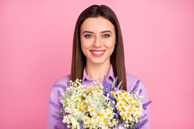 Retrato de primer plano de ella ella bonita atractiva encantadora bastante encantadora encantadora alegre alegre chica de pelo largo sosteniendo en las manos flores naturales frescas aisladas sobre fondo de color rosa pastel