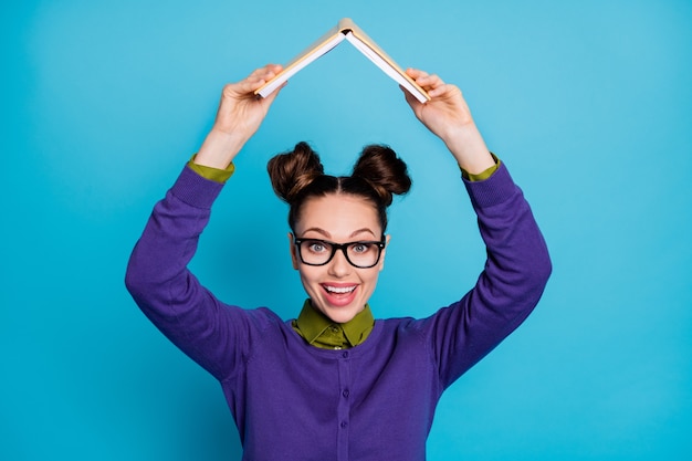 Foto retrato de primer plano de ella ella bonita atractiva inteligente inteligente alegre alegre divertida colegiala sosteniendo libro como techo aislado sobre fondo de color turquesa verde azulado verde vibrante brillo vivo