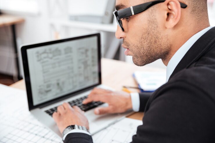 Foto retrato de primer plano de un empresario pensativo que trabaja con un portátil en la oficina
