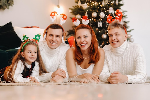 Retrato de primer plano de una familia feliz junto a un árbol de Navidad celebrando unas vacaciones.