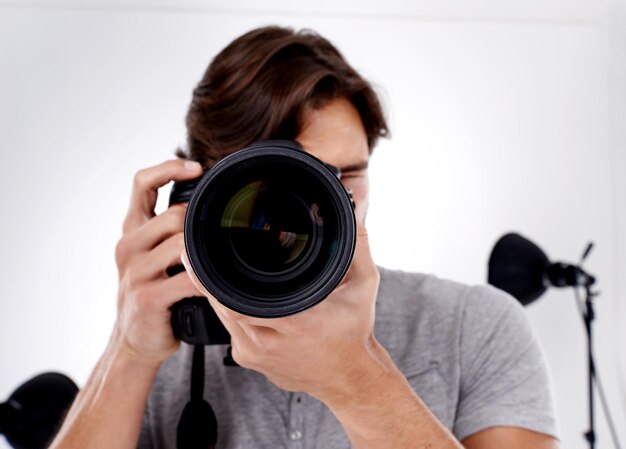 Retrato de primer plano y fotógrafo masculino con lente de cámara para fotos de estudio y sesión de fotos en Estados Unidos Videógrafo profesional hombre y DSLR para sesión de fotografía digital o macro de moda