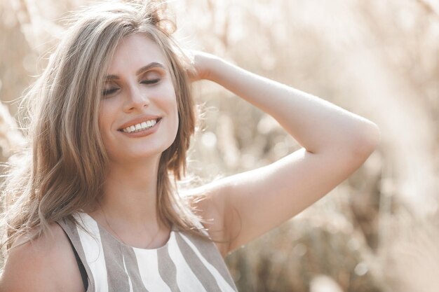 Retrato de primer plano de hermosa mujer rubia al aire libre Cara sonriente Encantadora dama en el fondo de verano Mujer emocional al aire libre