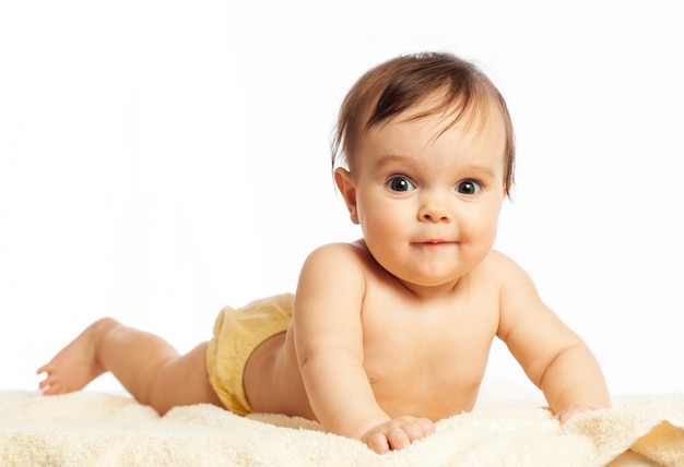 Retrato de primer plano de una hermosa niña curiosa de medio año con grandes ojos sobre un fondo blanco.