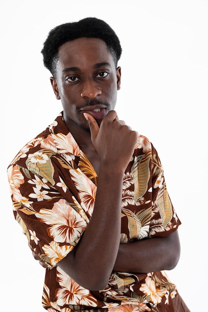 Retrato de primer plano de un hombre afroamericano mirando a la cámara con peinado elegante y estampado de camisa