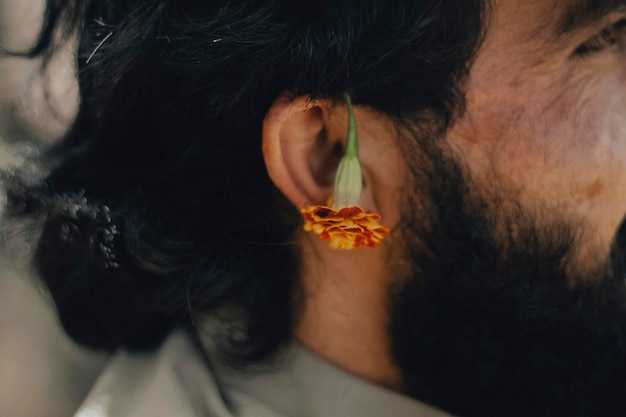 Foto retrato en primer plano de un hombre con una flor de naranja