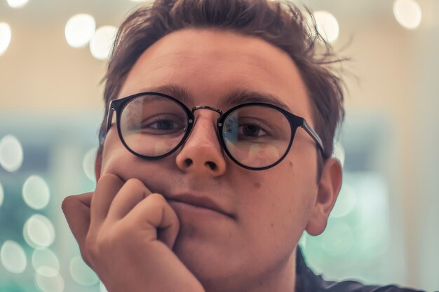 Foto retrato en primer plano de un hombre con gafas contra la luz iluminada