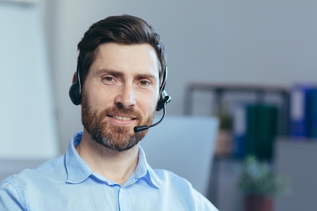 Retrato de primer plano de un hombre de negocios con auriculares para una videollamada un hombre mirando a la cámara sonriendo un operador del centro de llamadas