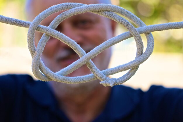 Foto retrato en primer plano de un hombre sosteniendo una cuerda