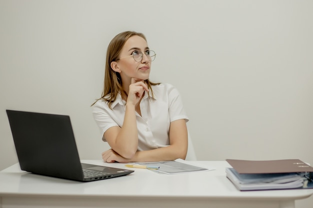 Retrato de primer plano de una joven gerente de oficina mujer confiada en su lugar de trabajo, lista para hacer negocios.