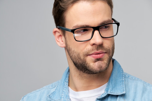 Retrato de primer plano de joven guapo caucásico en camisa de jeans.