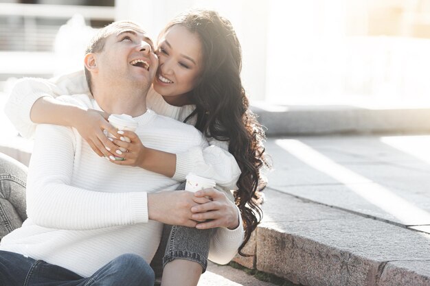 Retrato de primer plano de una joven pareja multirracial encantadora. Gente al aire libre. Hombre y mujer felices divirtiéndose en la ciudad.