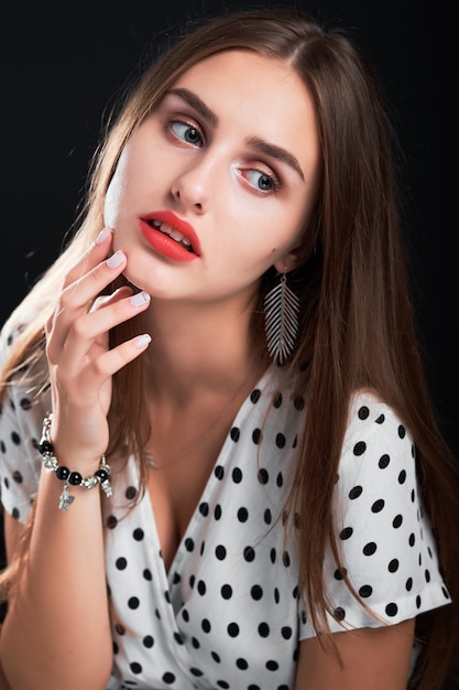 Retrato de primer plano de una joven con el pelo largo y labios rojos.