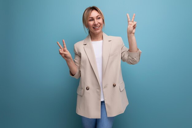 Retrato de primer plano de una joven rubia amable y positiva con un aspecto elegante y elegante en el estudio con