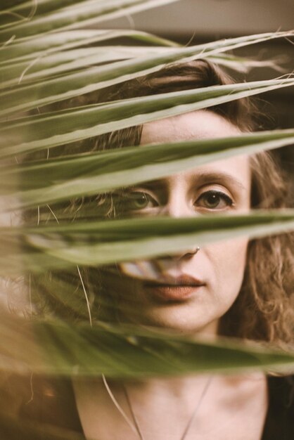 Foto retrato en primer plano de una joven vista a través de las plantas