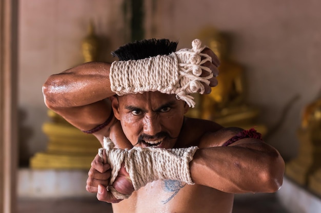 Retrato en primer plano de un luchador masculino de pie contra esculturas