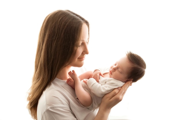 Retrato de primer plano de una madre joven y recién nacida Madre sostiene en sus brazos abraza suavemente besos a una hermosa hija recién nacida El concepto de amor maternidad feliz Foto sobre un fondo blanco