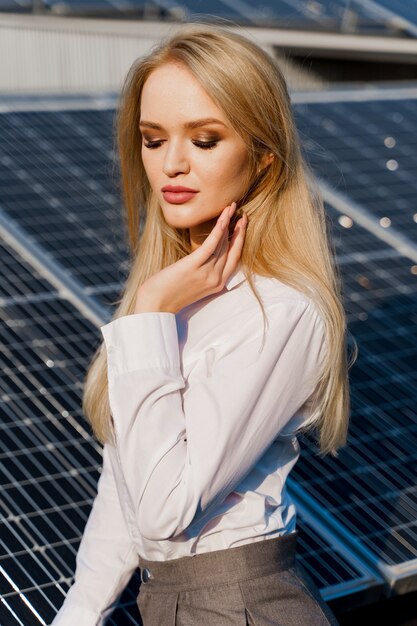 Retrato de primer plano de modelo rubia cerca de paneles solares