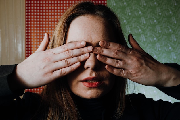 Foto retrato en primer plano de una mujer cubriendo la cara con la mano