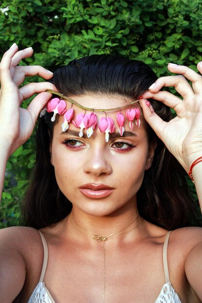 Foto retrato en primer plano de una mujer con flores rosas