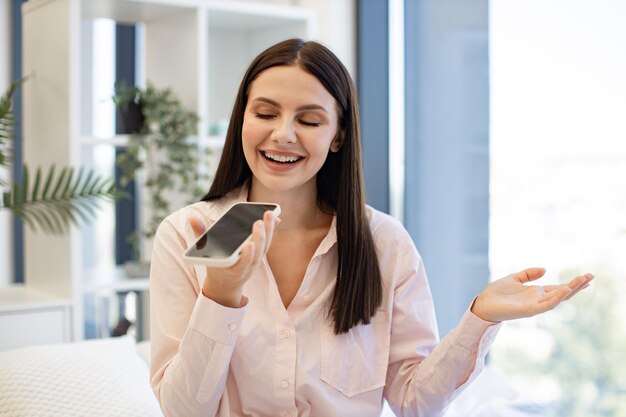 Retrato en primer plano de una mujer grabando una conversación en un teléfono inteligente moderno