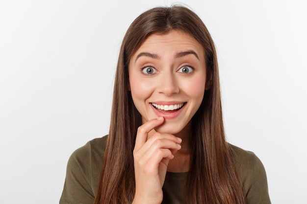 Retrato de primer plano de mujer hermosa sorprendida sosteniendo su cabeza con asombro y con la boca abierta.