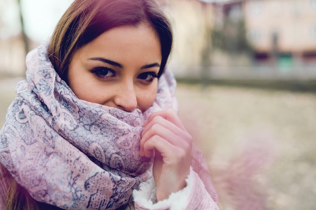 Foto retrato en primer plano de una mujer joven con bufanda