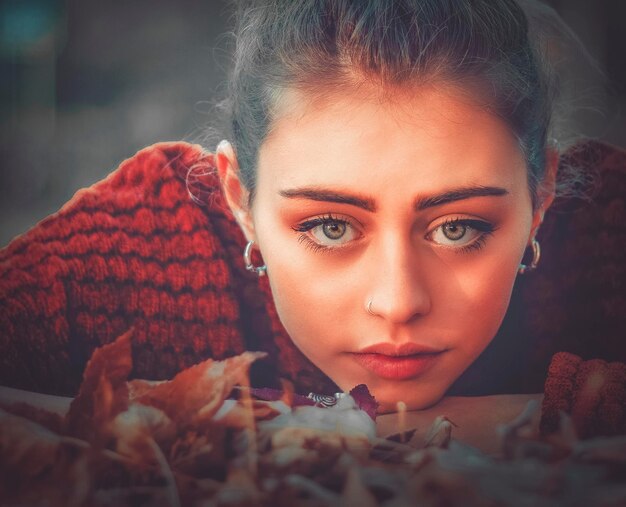 Foto retrato en primer plano de una mujer joven con hojas de otoño