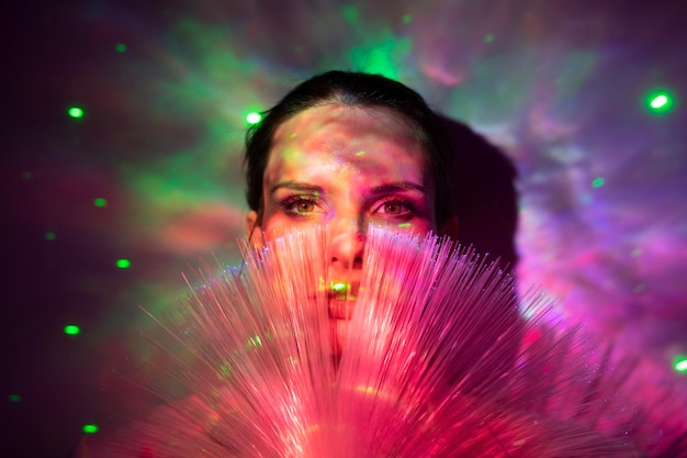 Retrato en primer plano de una mujer joven con luces iluminadas