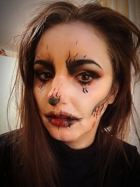 Retrato en primer plano de una mujer joven con un macabro maquillaje de Halloween