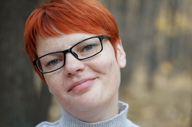 Retrato de primer plano de una mujer pelirroja con gafas