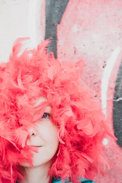 Retrato en primer plano de una mujer con plumas rojas en la cabeza