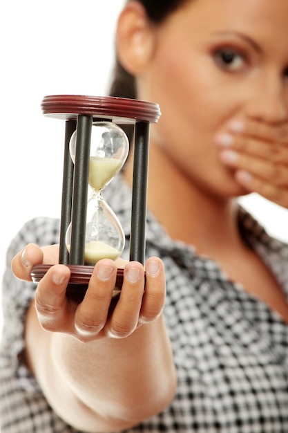 Retrato en primer plano de una mujer con un reloj de arena sobre un fondo blanco