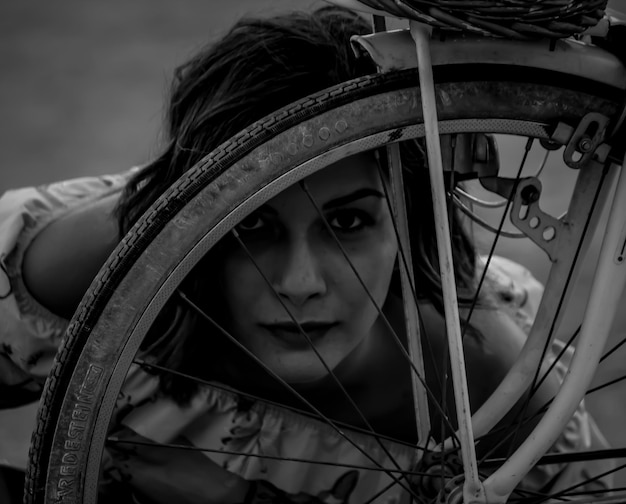 Foto retrato en primer plano de una mujer con la rueda de una bicicleta