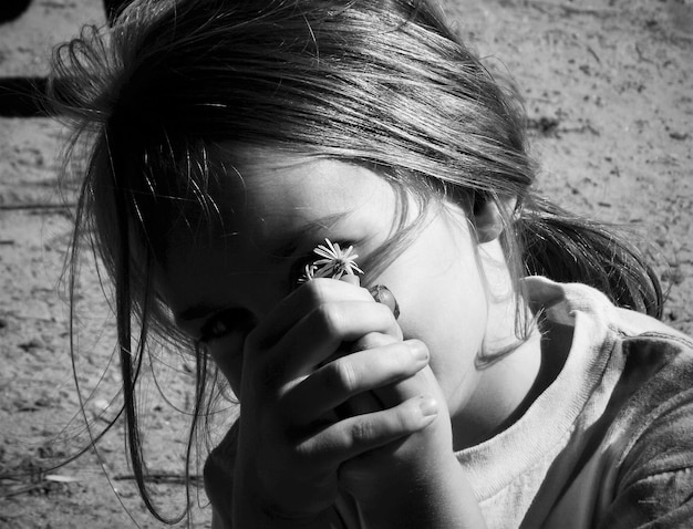 Foto retrato en primer plano de una niña con una flor