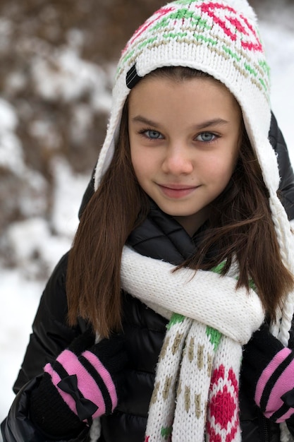 Retrato en primer plano de una niña linda en el parque de invierno