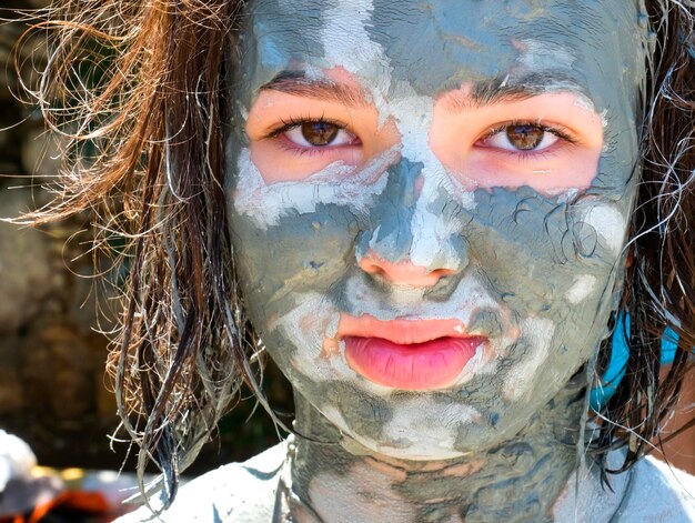 Retrato en primer plano de una niña con una máscara facial en la cara