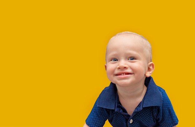 Retrato de un primer plano de un niño alegre feliz sobre un fondo amarillo. Día de los Inocentes