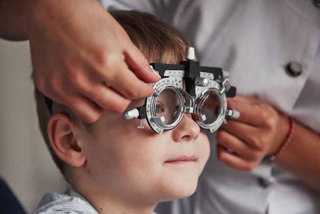 Foto retrato en primer plano de un niño con gafas especiales en el gabinete de un oftalmólogo